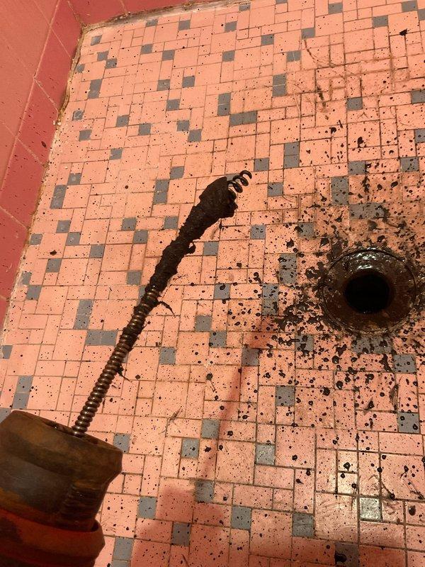 Responded to service call for blocked upstairs shower drain and glass debris in kitchen sink garbage disposal unit. Upon inspection of the bathroom, found shower drain completely obstructed with accumulated hair, soap residue, and organic debris causing complete water backup. Removed drain cover and extracted significant buildup of hair and sediment from the drain line. Cleared blockage using appropriate drain cleaning tools and verified proper water flow restoration. In the kitchen, safely removed glass fragments from the garbage disposal unit, inspected the disposal mechanism for damage, and confirmed operational integrity before testing. Both fixtures restored to full working order with no further issues detected.