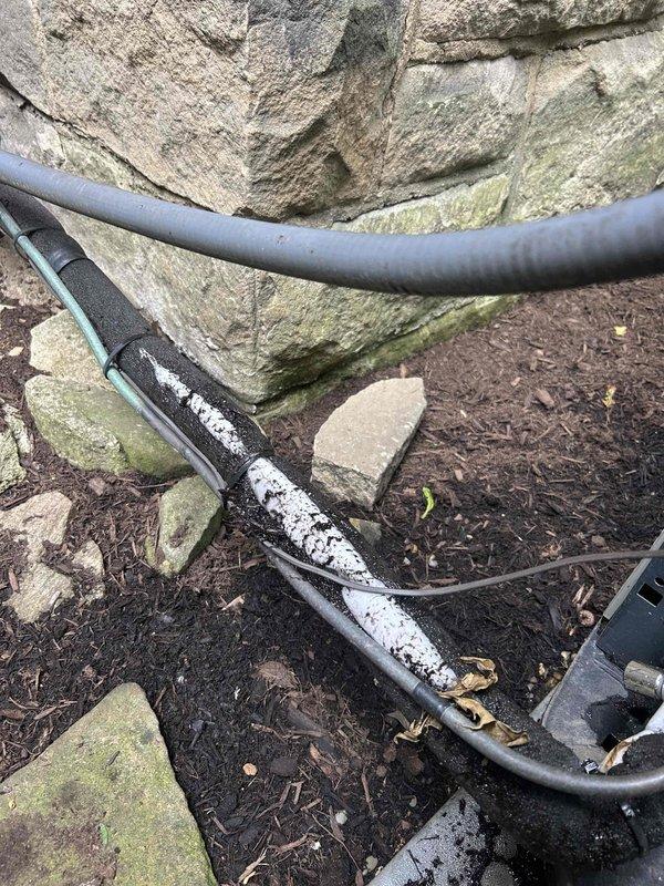 Responded to air conditioning service call for 5-year-old system with reported operational issues. Upon inspection, discovered significant debris accumulation including dried leaves and organic matter collected inside the air handler unit, which was restricting airflow and potentially impacting system performance. Inspected exterior refrigerant line insulation along foundation and noted deteriorated sections exposing underlying material, which could lead to efficiency loss and condensation issues. Cleaned debris from air handler housing and interior components to restore proper airflow. Documented existing insulation damage on exterior refrigerant lines for future maintenance consideration.