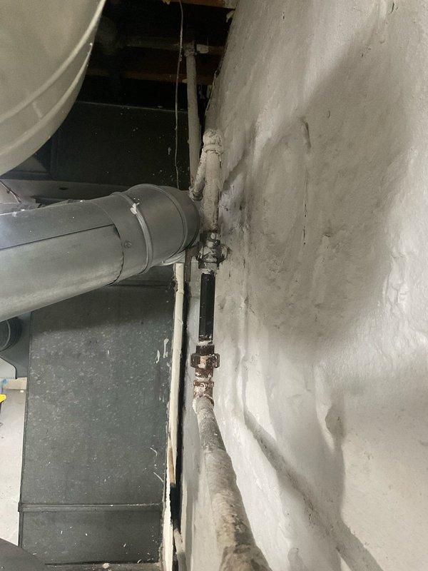 Responded to service call for water heater making hissing sound and actively leaking. Upon arrival, inspected AO Smith tanked water heater in basement utility area of ninety-year-old residential property. Assessed unit condition, copper supply piping, expansion tank, and associated valves and fittings. Documented existing installation with photographs showing water heater configuration, plumbing connections, and surrounding utility infrastructure including PVC drainage and metal piping penetrations through foundation walls. Identified source of hissing and water leak, evaluated overall system integrity and functionality.