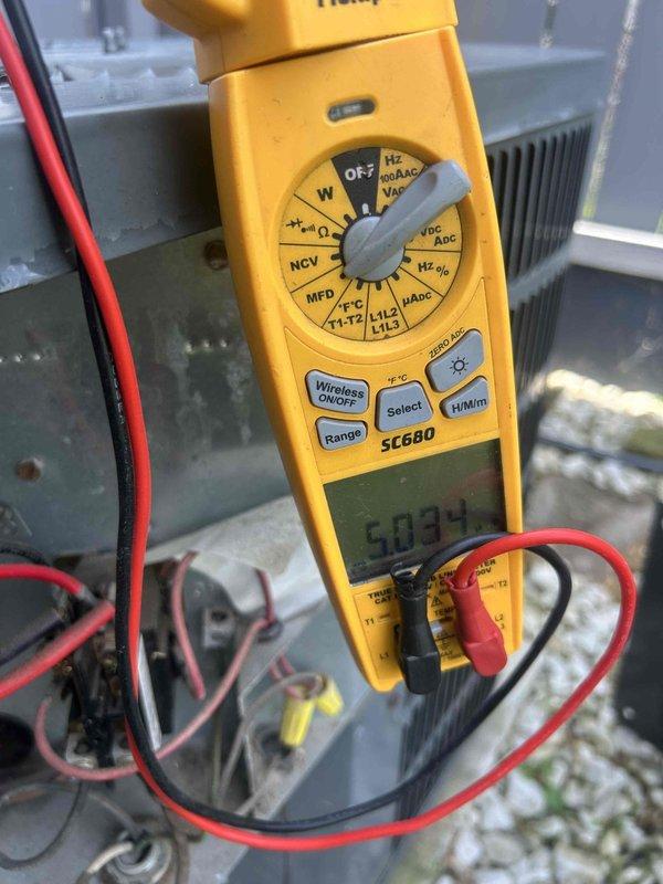 Responded to no cooling complaint with frozen evaporator coil. Upon inspection, diagnosed failed run capacitor causing compressor to hum without starting, resulting in system freeze-up. Verified diagnosis with electrical testing showing capacitor reading 5.0 microfarads, well below manufacturer specifications. Replaced defective capacitor, allowed system to thaw, and confirmed proper compressor amperage and normal operation upon restart.