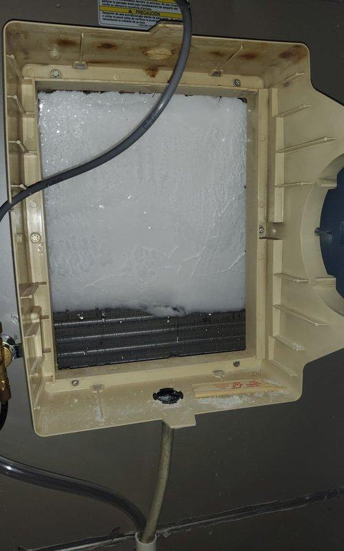 Responded to service call for 9-year-old air conditioning system with recurring issues from previous year. Upon inspection, discovered extensive frost buildup completely covering the evaporator coil assembly, indicating restricted airflow or potential refrigerant flow issues. Found significant debris accumulation including leaves and dirt within the outdoor unit's blower housing and motor assembly, blocking proper ventilation. Documented heavily frosted coil condition with ice crystals several inches thick obscuring the entire coil structure, as well as contaminated outdoor unit components. System showing signs of age with visible condensation issues on basement HVAC piping and non-functional upstairs zone, both previously addressed but recurring. Photographed conditions for documentation purposes. Diagnostic fee waived per management approval; customer responsible for labor and repair costs to address frozen evaporator coil, debris removal, airflow restoration, and resolution of recur