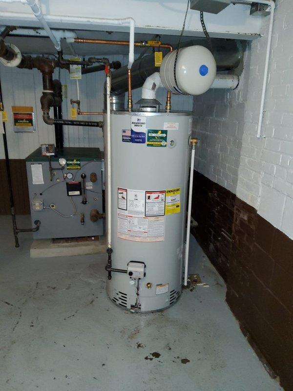 Installed a 75-gallon high recovery Bradford White Professional Series natural gas water heater, model RG275H6N, with 76,000 BTU input capacity in basement utility area. Connected copper supply lines with brass fittings, installed expansion tank with proper mounting, and verified all gas connections, pressure settings, and safety controls per manufacturer specifications. Unit tested and operational with all clearances meeting ANSI standards.