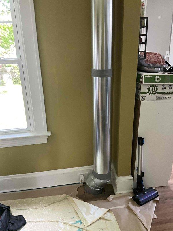 Conducted site assessment for ductwork replacement estimate. Evaluated existing vertical supply duct run extending from ceiling to floor level, noting current metallic duct installation along interior wall corner. Documented duct configuration, connection points, and spatial constraints for preparation of replacement estimate. Customer requested pricing for rerouting at least one duct run to improve system performance.