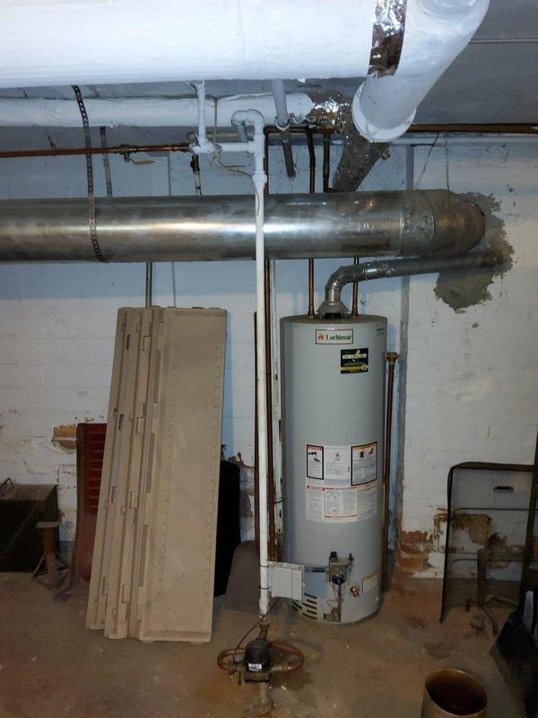 Responded to service call for multiple plumbing issues in 104-year-old residential property, including continuously running toilet in bathroom and sudden loss of cold water pressure at kitchen sink. Upon inspection of basement utility area, evaluated water heater installation, supply line configuration, and overall plumbing system condition. Assessed copper piping, PVC connections, and water distribution system for potential causes of low pressure and leaks mentioned by homeowner. Documented existing conditions including visible water staining on basement walls, aging infrastructure typical of early 1920s construction, and current mechanical system setup. Photographed water heater area and plumbing connections for service records and future reference.
