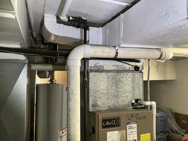 Conducted comprehensive on-site evaluation for complete HVAC system replacement including both furnace and air conditioning units. Assessed existing equipment in basement mechanical room, documented current system configuration including water heater proximity, ductwork layout, and available clearances for new equipment installation. Photographed existing furnace unit with connected supply and return ductwork, insulated piping, and electrical connections to provide accurate specifications for replacement system sizing and compatibility requirements.