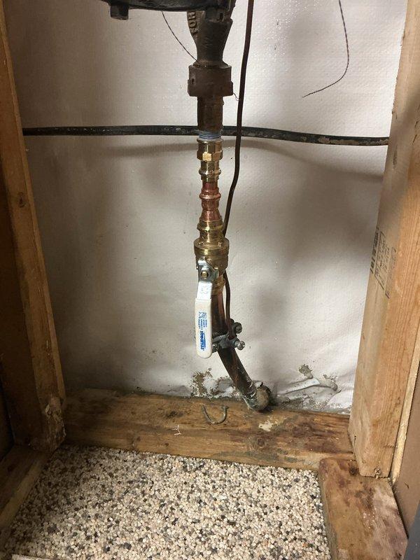 Replaced main water shutoff valve assembly with new brass valve and copper pipe fittings in utility space. Installation included proper connection to existing copper supply line with multiple brass connectors to ensure secure, leak-free operation. Work was completed with assistance to ensure proper shutoff functionality for the home's main water supply system.
