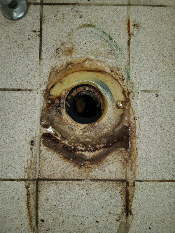 Responded to plumbing service call at a 60-year-old residential property for reported leak and clog issues. Upon arrival, conducted thorough inspection of bathroom plumbing system, focusing on toilet area and floor drainage components.

Identified significant water staining and rust buildup around floor drain, indicating chronic moisture exposure and potential drainage problems. Assessed toilet installation, water supply lines, and bidet attachment connections for signs of active leaks or deterioration. 

Cleared clog from floor drain system, removing accumulated debris and mineral deposits contributing to poor drainage and water backup. Addressed rust and corrosion issues on drain fixture, which had caused extensive staining on surrounding tile surfaces. 

Inspected all visible plumbing connections in bathroom, including toilet supply line, bidet water supply hose, and shut-off valves for proper operation and leak-free performance. Verified all fixtures were functioning correctly and 