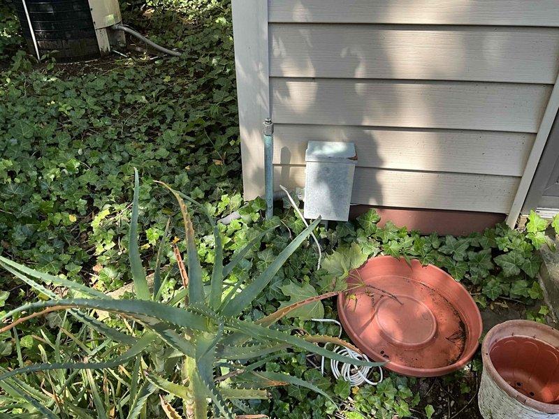 Conducted HVAC replacement estimate for a 30-year-old system. Evaluated existing Rheem unit located in basement utility area, noting moisture staining on concrete floor and condensate drainage conditions. Assessed exterior condenser location with overgrown vegetation requiring clearance for proper airflow and service access.