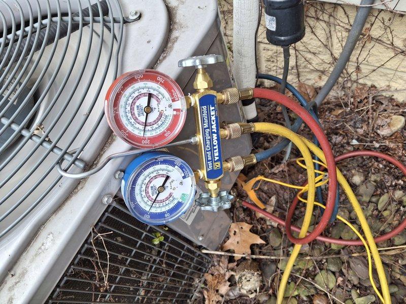 Completed comprehensive heating system tune-up and maintenance service. Performed thorough inspection of blower motor assembly and air filtration system, noting accumulated dust and normal wear on components. Conducted refrigerant pressure diagnostics using manifold gauge set on outdoor condensing unit, verifying system pressures and operational parameters to ensure proper heating cycle performance and efficiency.