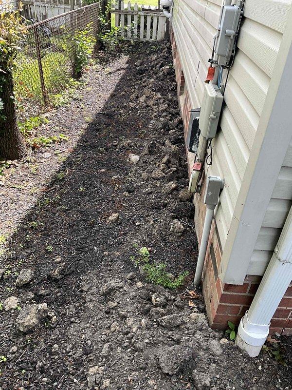 Conducted on-site evaluation of 20+ year old residential air conditioning system for replacement estimate. Documented existing outdoor condenser unit showing significant age-related deterioration, including visible rust staining, water damage, and weathering on exterior casing. Unit located in side yard on concrete pad with electrical disconnect box and conduit properly mounted on exterior wall. Assessed installation site conditions, photographed equipment placement area, and confirmed system specifications for replacement proposal.