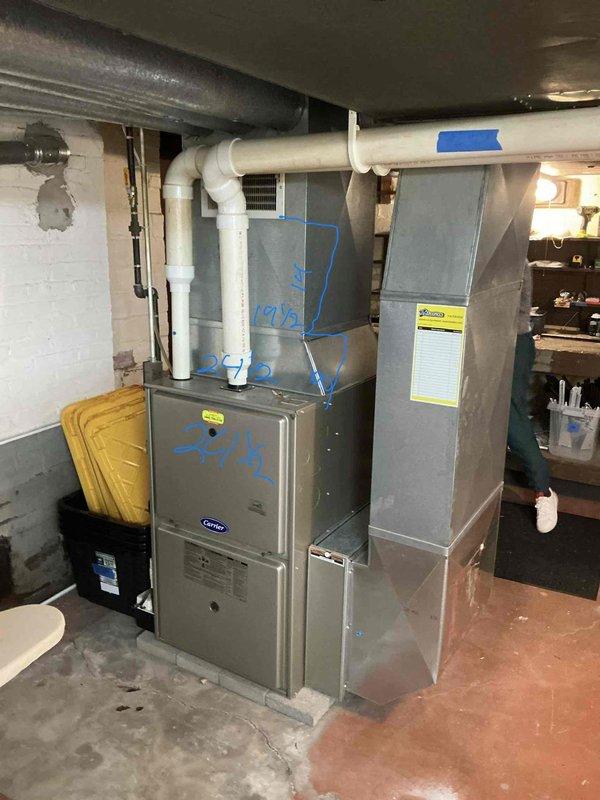 Conducted on-site HVAC system evaluation for equipment replacement estimate in residential basement mechanical room. Assessed existing Carrier furnace installation, electrical panel capacity, ductwork configuration, and PVC venting system to determine replacement specifications and installation requirements.