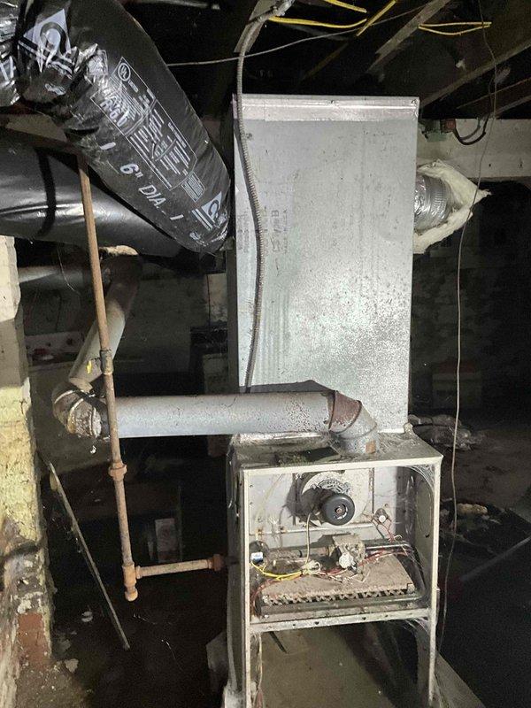 Conducted comprehensive on-site evaluation of existing gas-fired heating system in residential basement for equipment replacement estimate. Assessed aging furnace unit showing significant wear, discoloration, and operational decline, along with associated ductwork infrastructure including black flexible ducts and metallic distribution components. Documented current system configuration, copper piping connections, burner assembly condition, and overall mechanical room layout to provide accurate replacement specifications and equipment recommendations.
