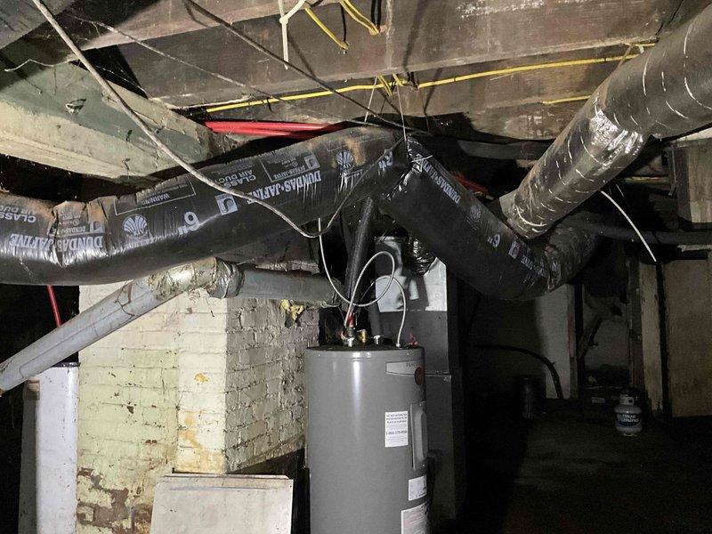Conducted comprehensive on-site evaluation of existing gas-fired heating system in residential basement for equipment replacement estimate. Assessed aging furnace unit showing significant wear, discoloration, and operational decline, along with associated ductwork infrastructure including black flexible ducts and metallic distribution components. Documented current system configuration, copper piping connections, burner assembly condition, and overall mechanical room layout to provide accurate replacement specifications and equipment recommendations.