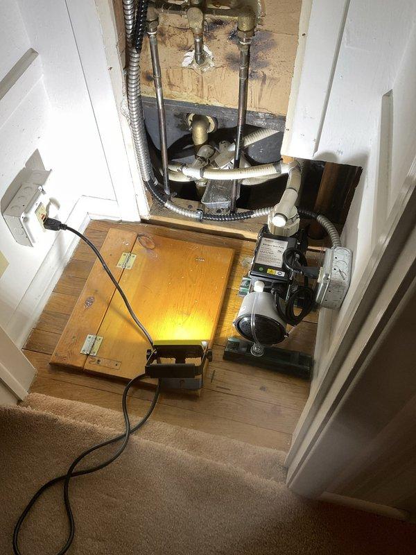 Responded to a report of a small drip from plastic piping associated with a jetted whirlpool bathtub in a 60-year-old residence. Accessed the plumbing system through an existing access panel in an adjacent closet, which provided visibility to the tub's circulation pump, associated piping connections, and related mechanical components. Upon inspection, identified the source of the leak in the plastic supply or return line connected to the jetted tub's pump assembly. Repaired the compromised connection point, verified all jet system plumbing connections for integrity, and tested the whirlpool system for proper operation and complete leak elimination. Confirmed no water intrusion or damage to surrounding flooring or walls in the access area.