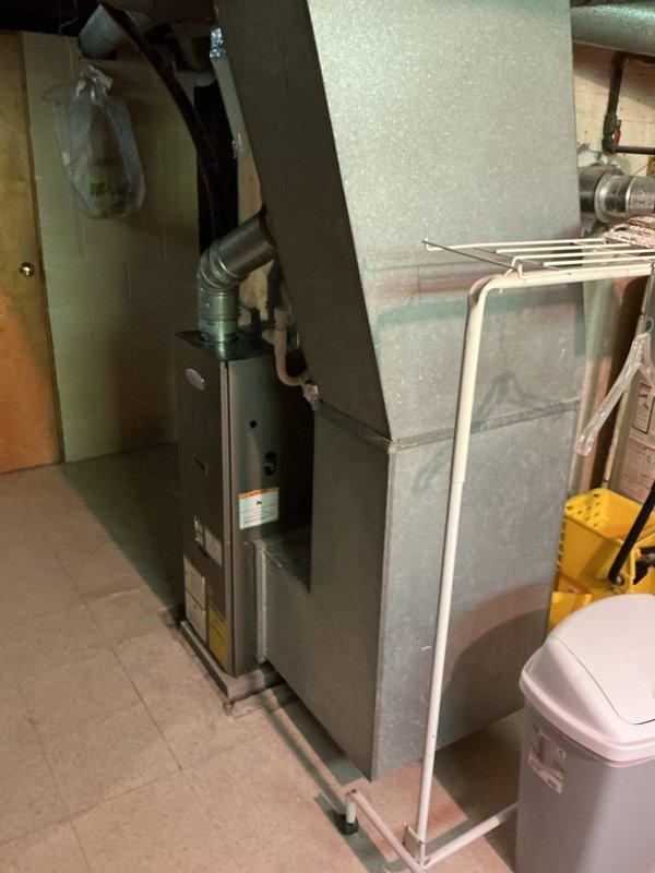 Responded to AC maintenance call at residential property. Upon arrival, inspected existing HVAC system located in basement utility area, including dark-colored furnace unit with exhaust piping and associated ductwork. Evaluated current equipment condition and age, documented system specifications, and provided comprehensive estimate for complete HVAC system replacement due to equipment age and efficiency considerations.