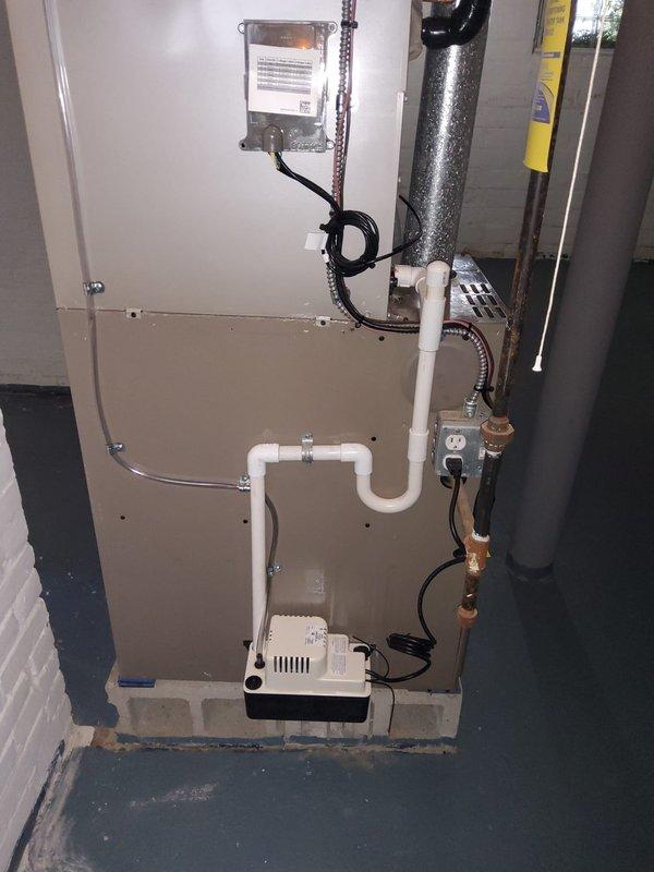Completed full air conditioning system installation in residential property. Installed new outdoor condensing unit on concrete pad with new electrical disconnect box. Ran new copper refrigerant line set from outdoor unit to indoor air handler, properly insulated and secured. Mounted new Ecobee smart thermostat with remote sensor for zone temperature monitoring and programmed system settings. Installed condensate pump with PVC drainage piping to handle air handler condensate removal. Made all electrical connections, evacuated and charged refrigerant system to manufacturer specifications, and verified proper system operation including airflow, temperature differential, and thermostat communication.