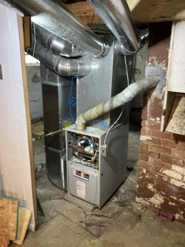 Conducted comprehensive assessment of existing furnace system located in unfinished basement area for replacement estimate. Documented current HVAC unit configuration, including vertical furnace installation with multiple branch ductwork connections and return air grille. Evaluated existing ductwork infrastructure, noted exposed metallic distribution system extending across ceiling joists, and assessed flexible duct connections to primary unit. Photographed furnace cabinet with access panel open to document internal burner assembly and control components for replacement specifications. Property was unoccupied at time of inspection, accessed via lockbox per arrangement.
