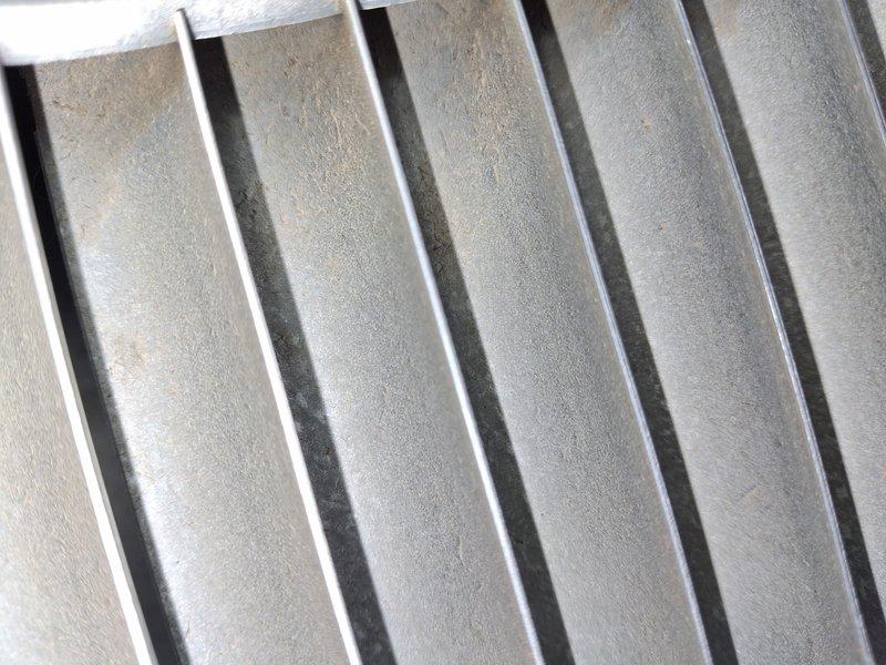 Completed comprehensive air conditioning tune-up and maintenance service on cooling system. Performed thorough inspection of condenser unit including coil fins, verified proper airflow through heat exchanger, and measured operating temperature at 265.9°F to ensure system performance within manufacturer specifications. Unit found in functional condition with even fin spacing maintained throughout condenser coil.