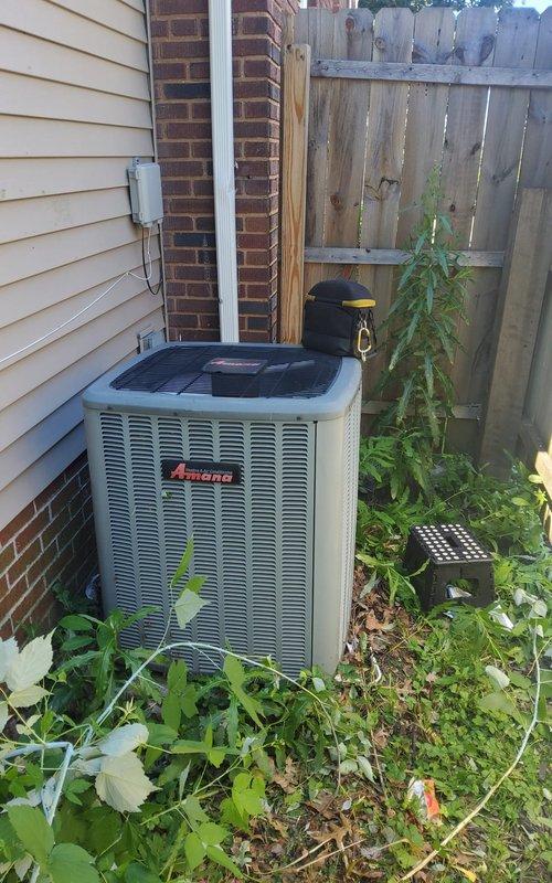 Completed preventive maintenance tune-up on residential Amana air conditioning system. Performed comprehensive inspection of outdoor condenser unit and indoor air handler, checked refrigerant levels, cleaned components, tested electrical connections, and verified proper system operation. Noted vegetation overgrowth around outdoor unit and recommended clearance maintenance for optimal airflow and efficiency.