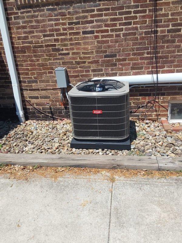Completed installation of Bryant split-system air conditioning system including outdoor condenser unit, attic-mounted air handler, and new ductwork throughout the home. The outdoor condenser was positioned on a pad against the brick exterior with proper clearances maintained, electrical disconnect box installed and labeled for both air handler and condenser circuits, and refrigerant lines run to the attic air handler. All new ductwork was installed in the attic space to provide cooling to the entire second floor, with additional supply runs extended to the first-floor living room and kitchen areas as space permitted. Electrical connections were completed with appropriate circuit protection, and the system was tested for proper operation upon completion.