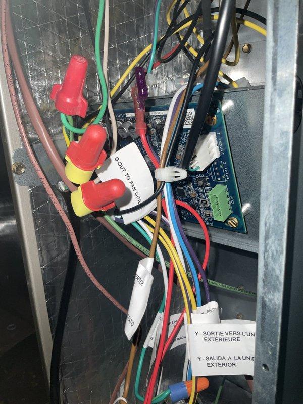 Responded to service call for second-floor air handler experiencing intermittent operation with startup noise but no fan or cooling function. Upon inspection, accessed control panel and identified wiring and control board issues preventing proper system operation. Examined circuit boards, wire connections, and control components within the air handler compartment. Verified proper wire terminations at connection points and inspected condition of control boards and associated wiring harnesses. Documented internal panel configuration and component layout showing multiple wire connections, circuit boards, and control relays. System evaluated for electrical continuity and proper control voltage at connection terminals.