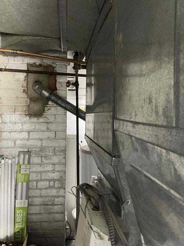 Conducted comprehensive evaluation of existing HVAC system for complete furnace and air conditioning replacement estimate. Assessed current equipment configuration including furnace unit with diamond-pattern louvered access panel, existing ductwork system, and associated PVC condensate drainage lines. Documented mechanical room layout, equipment placement, and existing infrastructure including electrical connections, gas piping, and ventilation components to determine optimal replacement specifications and installation requirements.