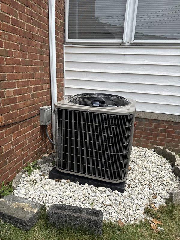 Completed full HVAC system installation including a new 90% AFUE gas furnace and 14 SEER air conditioning unit. The furnace was installed indoors with proper venting through metal ductwork, all electrical connections completed and secured, and blower motor assembly verified operational. The outdoor condensing unit was positioned on a polymer base pad in a gravel bed with concrete paver edging, refrigerant lines and electrical conduit run along exterior wall and properly connected. Both units were tested with diagnostic equipment to confirm proper operation, all safety controls verified functional, and system startup completed successfully.