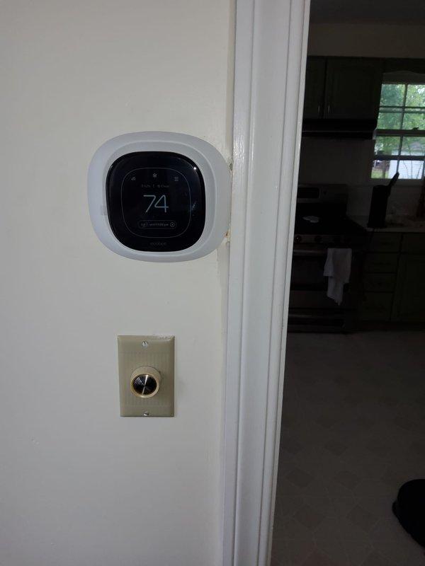 Completed installation of new air conditioning system with evaporator coil and Ecobee smart thermostat integrated with existing furnace. Positioned condensing unit at rear corner of sunroom, routed refrigerant line set and electrical wiring along exterior of house, evacuated system to proper vacuum levels, and verified all components operational with thermostat displaying correct temperature readings.