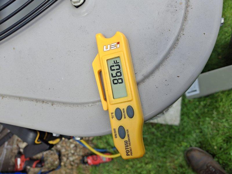 Completed comprehensive heat pump air conditioning tune-up on outdoor unit. Performed standard maintenance protocol including temperature differential measurements using calibrated digital instrumentation, recording 83.8°F reading during system evaluation. Inspected blower motor assembly, electrical connections, and refrigerant line set. All colored wiring connections verified secure with proper terminations. Unit operational and cooling effectively upon completion, though concrete pad shows age-related deterioration and rust staining from weather exposure that may require future attention for equipment longevity.