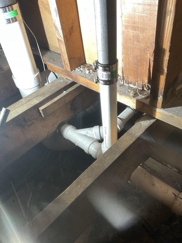 Replaced and rerouted PVC drainage piping in attic crawl space, installing new vertical and horizontal runs with proper fittings and transitions to black ABS connections. Verified proper drainage flow and completed all-day plumbing repair to restore full system functionality to residential bathroom toilet fixture.