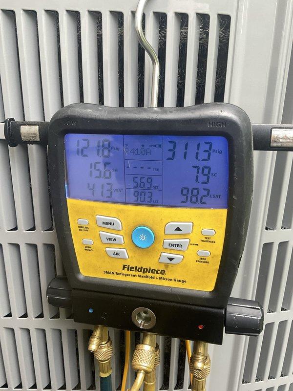 Completed preventative maintenance tune-up on residential air conditioning system. Performed system diagnostics using refrigerant manifold gauges to verify proper operating pressures and temperatures across the condenser unit. All measured parameters were within acceptable ranges, and the outdoor unit was found to be functioning properly with adequate airflow through the vertical grille sections.