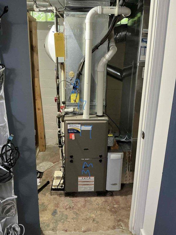 Conducted comprehensive on-site assessment of existing HVAC system for replacement estimate. Evaluated 25+ year-old air conditioning unit currently non-operational and approximately 12-year-old furnace installation in basement mechanical room. Documented existing equipment configuration including beige furnace unit with white PVC venting system, copper plumbing connections with shut-off valves, metal ductwork, and associated mechanical components. Photographed current system layout, piping arrangements, and equipment placement on concrete floor against cinder block walls to facilitate accurate replacement planning and equipment sizing recommendations.