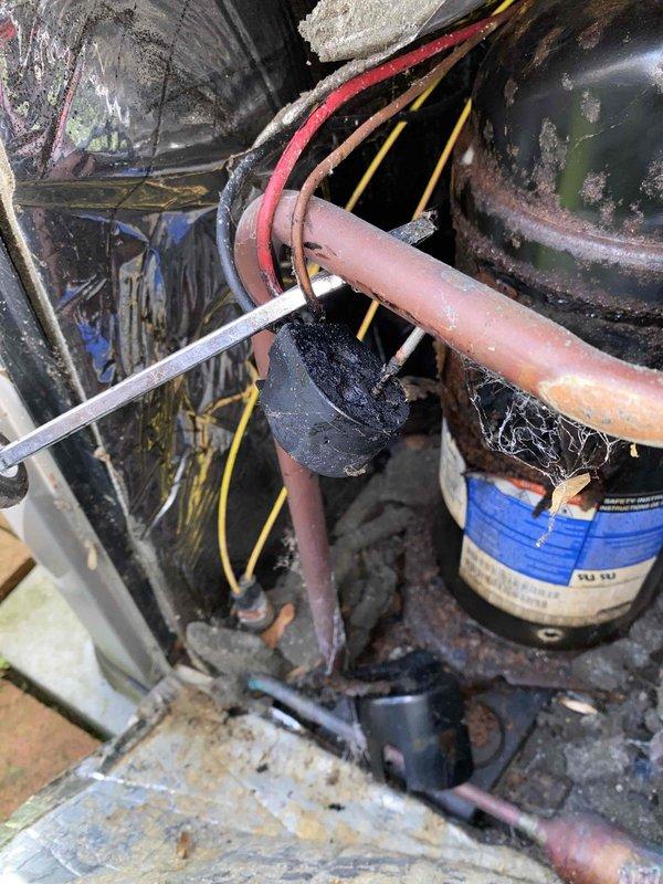 Responded to service call for 16-year-old central air conditioning system unable to cool below 74 degrees with abnormally loud blower operation. Upon inspection, discovered extensive rust and corrosion throughout the unit, heavily soiled evaporator coil with significant debris accumulation, and deteriorated wiring connections. System components showed severe lack of maintenance with compromised metal surfaces, oxidation on copper lines, and dirt buildup restricting airflow. Documented existing conditions with photos showing corroded housing, aged capacitor, and overall system degradation. Given the advanced age and extensive deterioration observed, recommended system replacement rather than repair due to compromised structural integrity and efficiency loss affecting cooling capacity and increased operational noise.