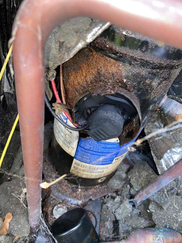 Responded to service call for 16-year-old central air conditioning system unable to cool below 74 degrees with abnormally loud blower operation. Upon inspection, discovered extensive rust and corrosion throughout the unit, heavily soiled evaporator coil with significant debris accumulation, and deteriorated wiring connections. System components showed severe lack of maintenance with compromised metal surfaces, oxidation on copper lines, and dirt buildup restricting airflow. Documented existing conditions with photos showing corroded housing, aged capacitor, and overall system degradation. Given the advanced age and extensive deterioration observed, recommended system replacement rather than repair due to compromised structural integrity and efficiency loss affecting cooling capacity and increased operational noise.