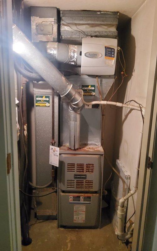Completed routine maintenance and tune-up on a five-year-old Goodman heating and cooling system. Performed standard inspection of furnace unit, blower motor assembly, ductwork connections, and Aprilaire humidifier. Observed moderate rust and corrosion on internal metal components and blower housing, typical for unit age and operating environment. Verified all electrical connections, tested blower motor operation, and confirmed proper airflow through flexible and rigid duct systems. Both heating and cooling systems operating within normal parameters with no immediate service needs identified.