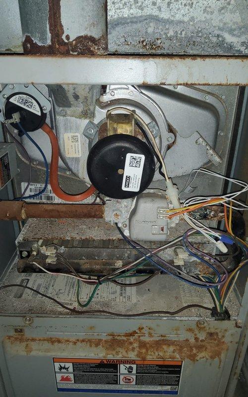 Completed routine maintenance and tune-up on a five-year-old Goodman heating and cooling system. Performed standard inspection of furnace unit, blower motor assembly, ductwork connections, and Aprilaire humidifier. Observed moderate rust and corrosion on internal metal components and blower housing, typical for unit age and operating environment. Verified all electrical connections, tested blower motor operation, and confirmed proper airflow through flexible and rigid duct systems. Both heating and cooling systems operating within normal parameters with no immediate service needs identified.