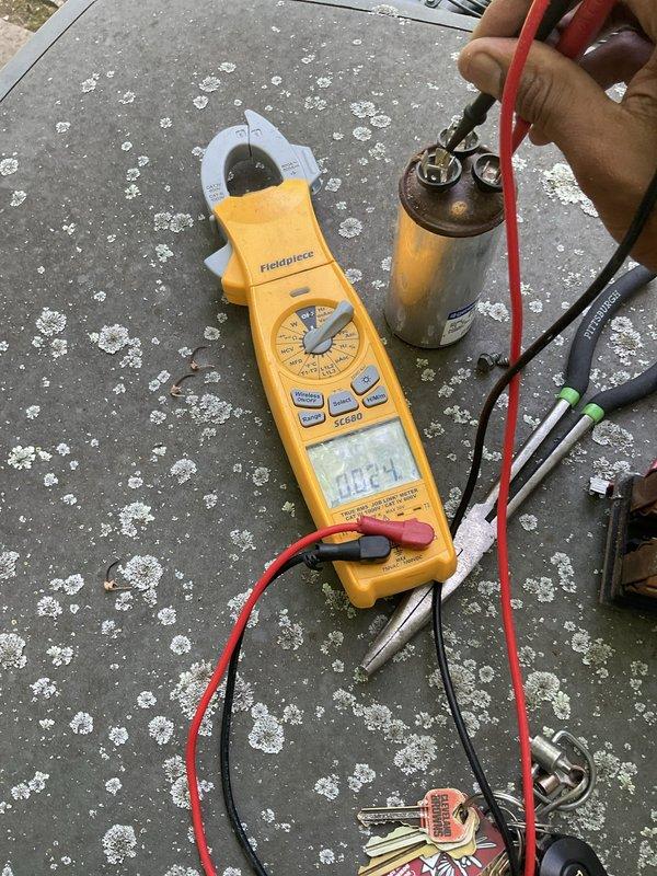 Responded to no cooling call affecting entire home. Upon arrival, performed diagnostic testing on outdoor condensing unit using clamp meter to check electrical components. Testing revealed failed capacitor with visible corrosion and deterioration on terminal connections. Removed defective capacitor and installed replacement unit. Verified proper electrical readings and system operation. Unit restored to normal cooling function.