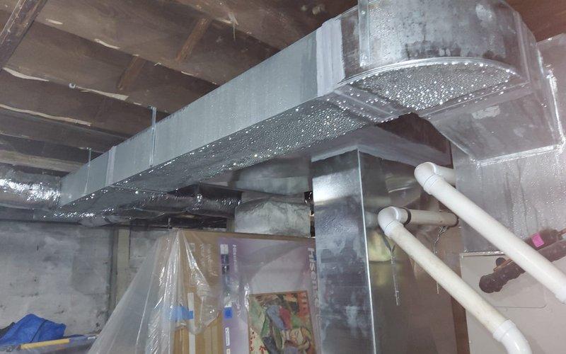 Responded to service call for cooling system leak on two-year-old AC unit. Upon arrival, performed thorough inspection of HVAC system and ductwork in basement mechanical area. Located source of water leak in condensate drainage system. Cleared blockage in condensate drain line and verified proper drainage flow. Inspected all accessible ductwork connections, refrigerant lines, and surrounding components for additional moisture or damage. Confirmed system operation and proper condensate removal. Documented conditions with photos showing ductwork installation and mechanical room layout. Unit tested and returned to normal cooling operation with no further leakage detected.