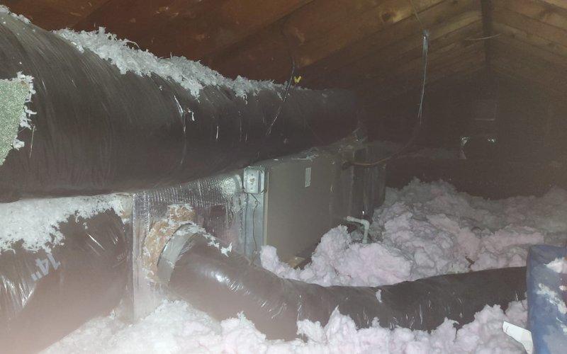 # HVAC Service Report: Water Leak Investigation and Resolution

Responded to service call for air conditioning unit experiencing water leakage. Unit was installed in 2019, with outdoor condenser approximately 7 years old. 

Upon arrival, conducted comprehensive system inspection to identify source of reported leak. Investigation revealed multiple contributing factors affecting system performance and moisture management.

Basement/crawl space inspection identified PVC condensate drain line configuration near foundation wall. Observed water staining and discoloration on floor surfaces indicating historical moisture intrusion. Pink fiberglass insulation showed signs of moisture exposure. Condensate drainage system components were examined for proper pitch, clogs, and functional operation.

Attic inspection revealed critical findings related to ductwork and moisture issues. Located flexible supply duct with extensive frost and ice accumulation along its surface, indicating severe temperatu