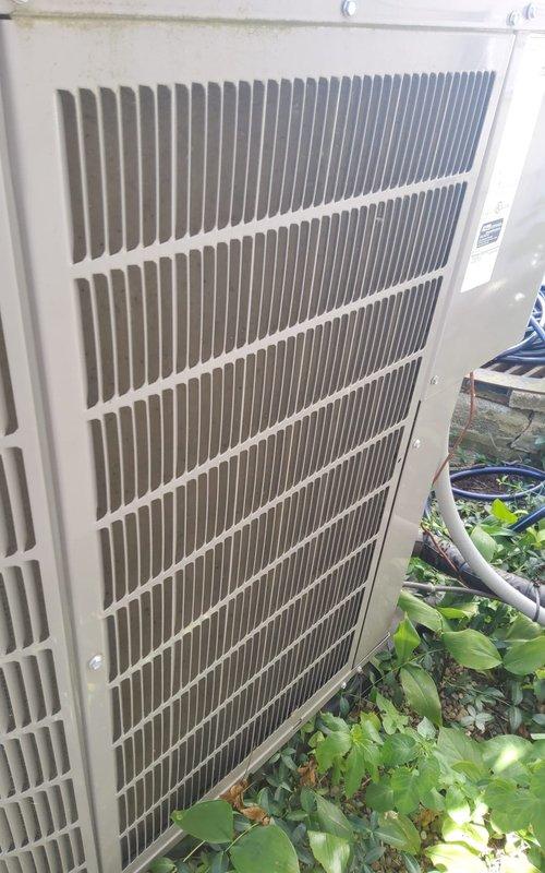 # Emergency No Cooling Call - 3-Year-Old System

Responded to emergency no cooling call for a three-year-old residential air conditioning system. Upon arrival, performed visual inspection of outdoor condenser unit, which showed significant dirt and debris accumulation on condenser coil fins and grille louvers. Documented equipment condition with photographs showing the beige/tan condenser unit positioned against house exterior with vegetation growth near base contributing to restricted airflow.

Conducted diagnostic assessment to identify root cause of cooling failure. Checked electrical connections, capacitor values, and refrigerant pressures. Inspected condenser fan motor operation and compressor functionality. Evaluated thermostat communication and indoor air handler performance.

Cleaned condenser coil using appropriate cleaning solution and pressure washing technique to remove dirt buildup affecting heat transfer efficiency. Cleared vegetation and debris from around unit perimeter