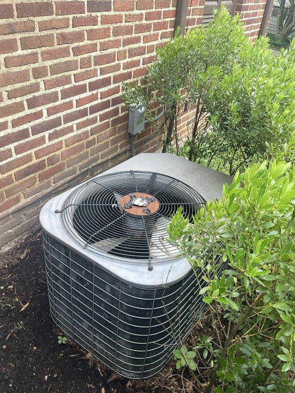 Responded to service call for non-operational air conditioning system affecting residential cooling. Upon arrival, confirmed the outdoor condenser unit had ceased functioning and was approximately 20 years old, well beyond its typical service life. Customer indicated a previous repair had been attempted and requested an evaluation for complete system replacement. Performed visual inspection of the outdoor condenser unit positioned against the exterior brick wall, noting the age and condition of the equipment. Examined the indoor air handler unit located in the attic space, observing the existing ductwork configuration and installation. Documented system components with photographs for replacement estimate preparation. Provided professional assessment and recommendations for new equipment installation based on the failed condenser and advanced age of the current system.