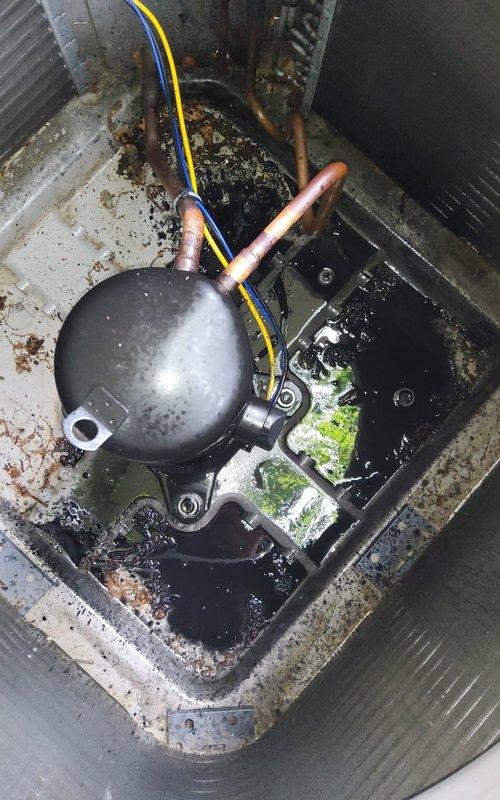 Responded to no cooling complaint on 3-year-old AC unit that had compressor replacement completed two months prior. Upon inspection, discovered significant contamination in condensing unit base with pooled liquid, debris, and biological growth around compressor and refrigerant lines. System evaluation revealed potential secondary failure or contamination-related issue affecting cooling performance. Documented equipment condition with photos showing deteriorated base pan, moisture accumulation, and compromised cleanliness of critical components requiring further diagnostic assessment to determine root cause of recurring cooling failure.