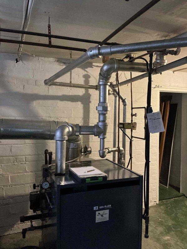 Conducted estimate for replacement of approximately 25-year-old steam boiler system currently in operation. Evaluated existing equipment and discussed power vent conversion options as an alternative to traditional chimney venting, per customer's preference and willingness to eliminate existing chimney infrastructure. Documented current boiler configuration, piping network including copper and black iron steam lines, and existing venting arrangement to provide comprehensive replacement options and specifications.