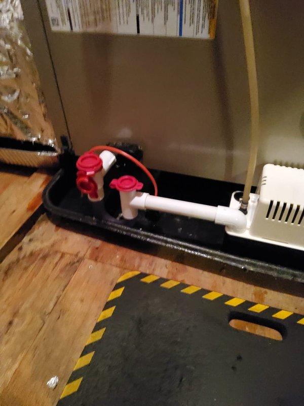 Responded to service call for attic-mounted air handler with reported evaporator coil leak. Upon inspection, confirmed active leak at evaporator coil with condensate accumulating in drain pan requiring frequent manual emptying. Assessed condensate drainage system including primary drain pan, overflow safety switch, and condensate pump assembly. Documented existing conditions with photographs showing drain pan configuration, PVC drain lines, and condensate pump installation for further evaluation and repair planning.
