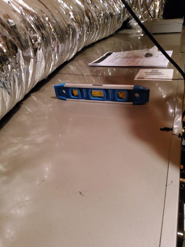 Responded to service call for attic-mounted air handler with reported evaporator coil leak. Upon inspection, confirmed active leak at evaporator coil with condensate accumulating in drain pan requiring frequent manual emptying. Assessed condensate drainage system including primary drain pan, overflow safety switch, and condensate pump assembly. Documented existing conditions with photographs showing drain pan configuration, PVC drain lines, and condensate pump installation for further evaluation and repair planning.
