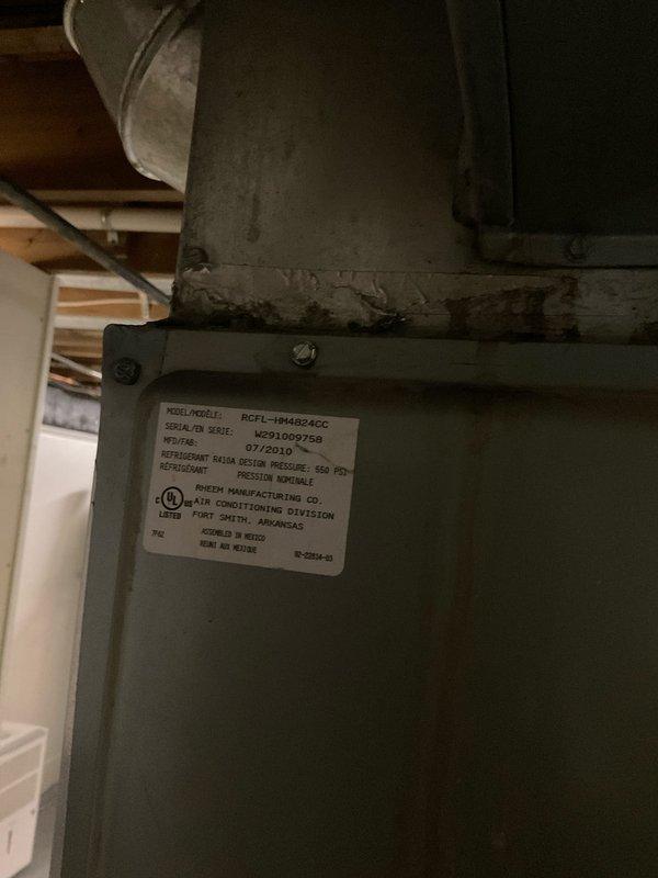 Performed comprehensive routine maintenance on a 15-year-old Rheem air conditioning system (Model RCFL-194482ACC, Serial MG91069758, manufactured 07/2010). Inspected indoor air handler unit located in basement mechanical room and outdoor condensing unit. System was operating properly with no reported issues prior to service. Completed standard AC tune-up procedures including visual inspection of all components, verification of proper airflow through ductwork, checking refrigerant levels, cleaning condenser coils, inspecting electrical connections, and testing system operation. All equipment found to be functioning within normal parameters. Documented equipment condition with photos of indoor unit and manufacturer data plate for maintenance records. System cleared for continued operation with recommendation to monitor performance given age of equipment.
