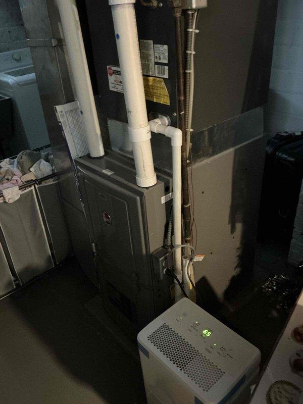 Responded to emergency service call for non-cooling air conditioning system with unknown equipment age. Upon inspection of the basement mechanical area and exterior condenser unit, documented existing HVAC system configuration including furnace, outdoor condensing unit, associated refrigerant lines, electrical disconnect, and condensate drainage system. Assessed overall system condition, noting aged equipment and installation characteristics. Provided comprehensive estimate for complete HVAC system replacement to restore cooling functionality and improve system efficiency.