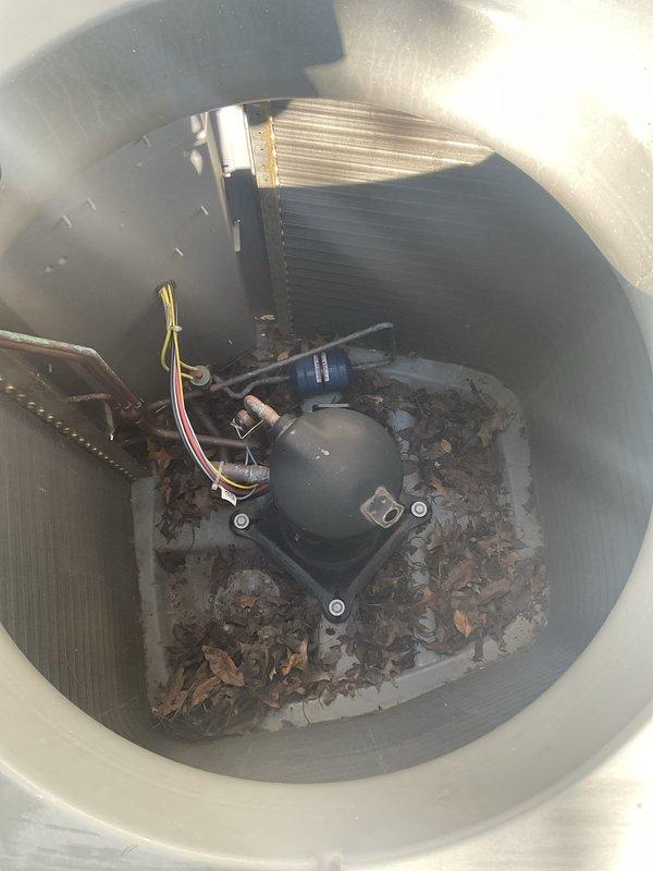 Performed advanced coil cleaning on outdoor condensing unit that had accumulated significant debris, leaves, and dirt buildup affecting system performance. Removed side panels and condenser fan motor to access coil compartment, back-flushed condenser coil to restore proper heat transfer efficiency, and cleared all leaves and organic debris from interior housing around compressor. Reassembled unit and restored to proper operating condition.