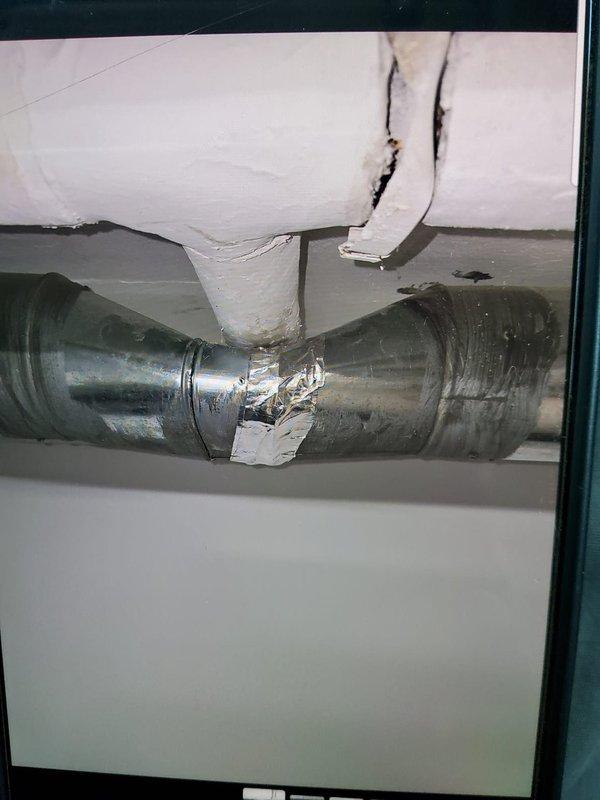 Responded to no cooling complaint on six-year-old air conditioning system. Upon arrival, performed diagnostic testing using refrigerant manifold gauges and temperature measurements. System pressures indicated low refrigerant charge with suction pressure reading 45.6 psig and evaporator temperature at 87.7°F, confirming insufficient cooling capacity. Inspected outdoor condensing unit and indoor air handler components. Located compromised ductwork insulation in attic space with visible tears and gaps affecting system efficiency. Flexible duct connections showed proper sealing with foil tape, but surrounding fiberglass insulation exhibited deterioration and sagging sections that could impact overall system performance. Documented system conditions with photos for member records. Recommended refrigerant recharge and ductwork insulation repair to restore proper cooling operation.