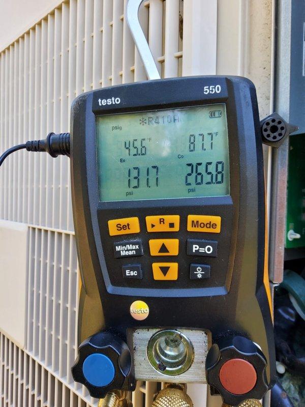 Responded to no cooling complaint on six-year-old air conditioning system. Upon arrival, performed diagnostic testing using refrigerant manifold gauges and temperature measurements. System pressures indicated low refrigerant charge with suction pressure reading 45.6 psig and evaporator temperature at 87.7°F, confirming insufficient cooling capacity. Inspected outdoor condensing unit and indoor air handler components. Located compromised ductwork insulation in attic space with visible tears and gaps affecting system efficiency. Flexible duct connections showed proper sealing with foil tape, but surrounding fiberglass insulation exhibited deterioration and sagging sections that could impact overall system performance. Documented system conditions with photos for member records. Recommended refrigerant recharge and ductwork insulation repair to restore proper cooling operation.
